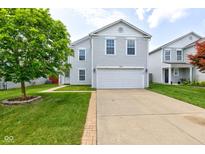 Charming two-story home featuring light gray siding, a spacious two-car garage, and a well-manicured front yard with lush green grass at 9593 W Constellation Dr, Pendleton, IN 46064