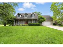 Charming brick home featuring a welcoming front porch and well-maintained landscaping at 1013 Chapman Blvd, Greenfield, IN 46140