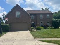 Charming two-story brick home with a well-manicured lawn and an attached two-car garage at 11123 Garrick St, Fishers, IN 46038