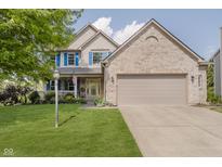 Charming two-story home featuring blue shutters, a covered front porch, and a well-manicured lawn at 13214 Dunwoody Ln, Carmel, IN 46033