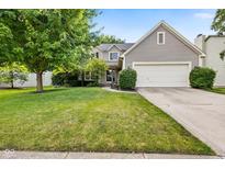 Charming two-story home featuring a well-manicured lawn, mature trees, and a two-car garage at 13470 Shakamac Dr, Carmel, IN 46032