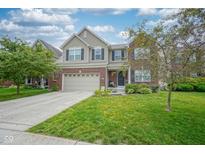 Charming two-story home featuring a brick and vinyl exterior, attached two-car garage, and well-manicured lawn at 13884 Wendessa Dr, Fishers, IN 46038