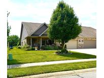Charming brick home features a manicured lawn, lovely landscaping, and an attached three-car garage at 1688 Magnolia Dr, Greenwood, IN 46143