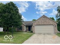 Charming brick ranch home with an attached two-car garage and lovely, mature landscaping at 17717 Cedarbrook Dr, Westfield, IN 46074