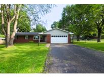 Charming single-story brick home with a well-manicured lawn and long driveway at 207 E Waterbury Rd, Indianapolis, IN 46227