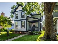 Charming two-story home features blue and grey siding, covered porch, well-kept landscaping, and mature trees at 2347 N Pennsylvania St, Indianapolis, IN 46205