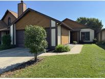 Charming home showcasing a well-maintained lawn, complemented by a lovely tree and a two-car garage at 4049 Zinfandel Way, Indianapolis, IN 46254