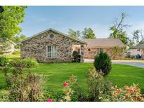 Well-maintained brick house with a green lawn, mature shrubs, and a charming garden at 450 W 250 N, Lebanon, IN 46052