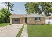 Charming single-story home with stone facade, attached garage, and well-maintained lawn at 5134 Rinehart Ave, Indianapolis, IN 46241