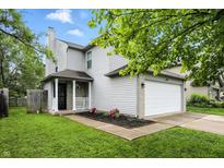 Charming two-story home featuring a well-maintained lawn and attached two-car garage at 6495 Titania Dr, Indianapolis, IN 46236