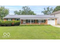 Charming single-story brick home with a well-manicured lawn, covered porch, and attached garage at 814 N Noble St, Greenfield, IN 46140