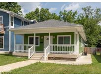 Charming bungalow with a green exterior, white trim, a front porch, and a well-manicured lawn at 1122 W 35Th St, Indianapolis, IN 46208