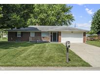 Charming single-story brick home with a well-manicured lawn and a cozy front porch at 1346 Carroll White Dr, Indianapolis, IN 46219