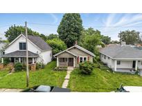 Charming single-story home with a cozy front porch and mature trees in a residential neighborhood at 1550 Hoefgen St, Indianapolis, IN 46203