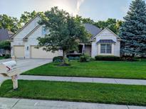 Charming brick home with a well-manicured lawn, mature trees, and a convenient two-car garage at 16254 Quartz Dr, Noblesville, IN 46060
