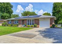 Charming brick home with solar panels, attached garage, and a well-manicured front lawn at 2020 Rosedale Dr, Indianapolis, IN 46227