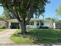 Charming single-story home with a well-maintained lawn and a large tree in the front yard at 2113 W Barcelona Dr, Muncie, IN 47304