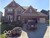 Two-story brick home with manicured lawn and an attached two-car garage and concrete driveway at 2783 W High Grove Cir, Zionsville, IN 46077