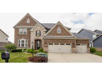 Stunning brick home featuring an attached two-car garage and professionally landscaped yard at 2783 W High Grove Cir, Zionsville, IN 46077