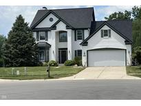Charming two-story white brick home with green trim, two-car garage, and well-maintained lawn at 4655 Rockcress Ct, Zionsville, IN 46077