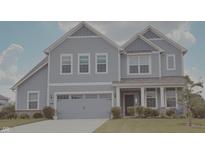 Charming two-story home showcasing light-blue siding, a two-car garage and a well manicured lawn at 5527 Mahogany Dr, Noblesville, IN 46062
