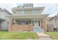 Charming two-story home with a welcoming front porch and brick accents at 555 N Oakland Ave, Indianapolis, IN 46201