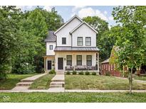 Charming two-story home with a welcoming front porch and a well-manicured lawn at 5678 N College Ave, Indianapolis, IN 46220