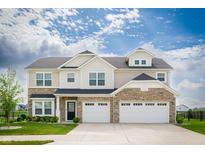 Beautiful two-story home with a stone facade and attached three-car garage, complete with manicured lawn at 7147 Prelude Rd, Brownsburg, IN 46112