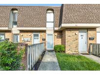 Charming brick townhome with well-manicured lawn and inviting entryway at 7468 Countrybrook Dr, Indianapolis, IN 46260