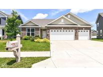 Charming brick home featuring a two-car garage, manicured lawn, and lovely curb appeal at 8864 Rowling Way, Indianapolis, IN 46239