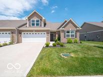 Charming brick home featuring a two-car garage, well-maintained lawn, and inviting curb appeal at 8866 Twain Ln, Indianapolis, IN 46239
