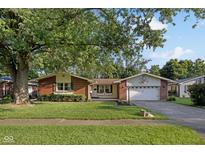 Charming brick and vinyl home featuring a basketball hoop above a two-car garage at 911 Glendale Dr, Lebanon, IN 46052
