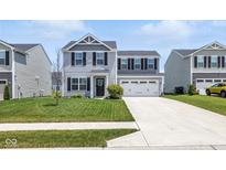 Charming two-story home featuring a manicured lawn and a two-car garage with a concrete driveway at 9855 Oakmont E E Dr, Pendleton, IN 46064