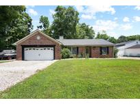Charming brick home featuring an attached garage and well-manicured lawn at 10519 N Antioch Rd, Mooresville, IN 46158