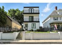 Modern three-story home with white siding, black trim, and a double-balcony facade offers stylish curb appeal at 1405 E Vermont St, Indianapolis, IN 46201
