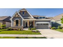 Charming two-story home featuring a gray exterior, manicured lawn, and welcoming front porch at 15600 Woodford Dr, Westfield, IN 46074
