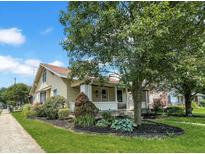 Charming home with a landscaped front yard and mature trees on a sunny day at 1602 California St, Columbus, IN 47201