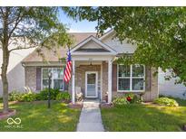 Charming brick home with covered porch, manicured lawn, and American flag at 2017 Shadow Creek Blvd, Columbus, IN 47201