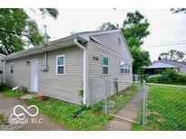 Beige single story house with lawn and chain link fence at 2305 Barnor Dr, Indianapolis, IN 46219
