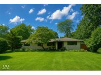 Charming single-story home with a well-manicured lawn and mature trees at 2922 E 62Nd St, Indianapolis, IN 46220