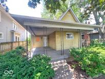 Charming bungalow with a covered front porch and mature landscaping at 434 N Bradley Ave, Indianapolis, IN 46201