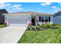 Charming single-story home featuring a manicured lawn and inviting curb appeal with lush floral landscaping at 5120 Woodhurst Ln, Indianapolis, IN 46239
