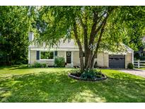 Charming single story home featuring a manicured lawn, gray garage, and a tree in the front yard at 6491 N Oxford St, Indianapolis, IN 46220