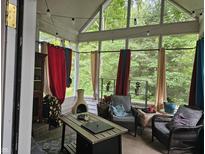 Relaxing sunroom with rustic wood pile, chimney and an array of colorful decor and natural lighting at 8423 Mud Creek Rd, Indianapolis, IN 46256