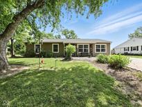 Ranch-style home showcasing a well-manicured lawn and mature trees under a bright blue sky at 1039 Eastlawn Dr, Whiteland, IN 46184