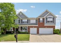 Charming two-story home with a brick and siding exterior, attached two-car garage, and well-manicured lawn at 10716 Patoka Rd, Indianapolis, IN 46239