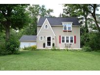 Inviting two-story home with red shutters, front patio and well maintained lawn at 115 Northshore Blvd, Anderson, IN 46011