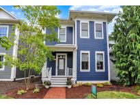 Charming two-story home featuring blue siding, white trim, a welcoming porch, and landscaped front yard at 12874 Tradd St, Carmel, IN 46032