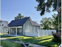 Charming home featuring new gray siding, white trim, metal roof, fenced yard, and a cozy front porch at 206 Olive St, Arcadia, IN 46030