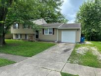 Charming exterior of home featuring a one car garage, light siding, and a well maintained lawn at 2626 Fairhaven Dr, Indianapolis, IN 46229